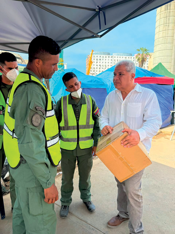 distribution des cartons de housses Tanaguarena aux équipes en charge des investigations dans les décombres